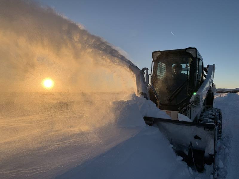 Rocky Top skidsteer blower throwing snow — commercial snow removal Durango
